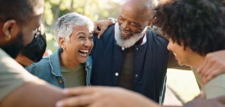 Photograph: Happy multi-generational family embracing and laughing outdoors.